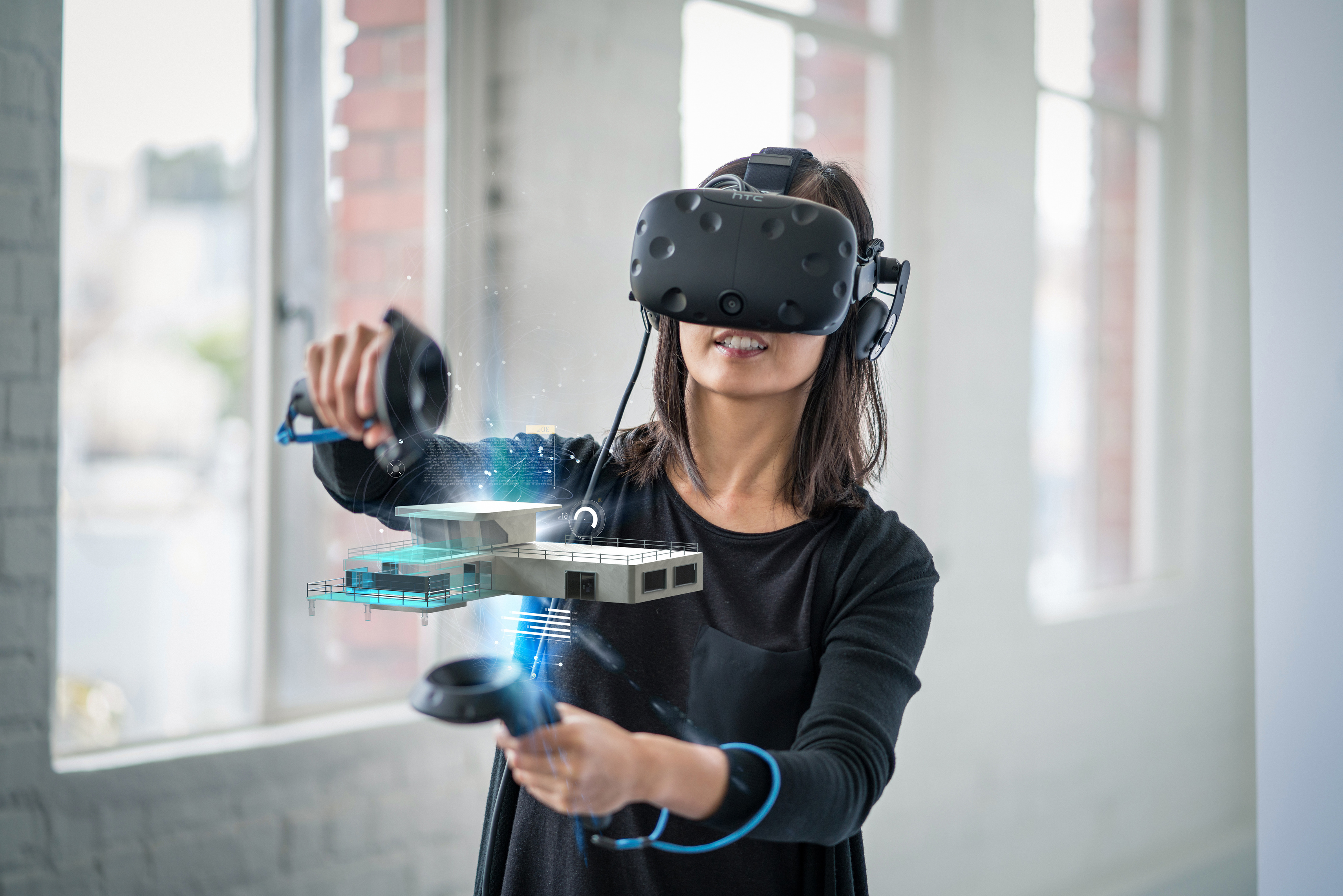Frau mit VR-Brille und Steuerung hält die Steuerungselemente rund um ein virtuelles Gebäude